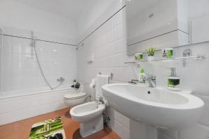 a white bathroom with a sink and a toilet at Domaso front lake in Domaso +20 photos