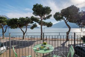 a table and chairs with a view of the water at Domaso front lake in Domaso
