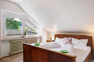 a bedroom with a bed in a room with a window at Ferienwohnung Haus Waldfee in Sulzburg