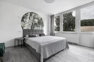 a bedroom with a bed and a large window at Apartment am Wald in Dörentrup