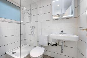 a white bathroom with a toilet and a sink at Apartment am Wald in Dörentrup +21 photos