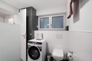 a bathroom with a washing machine and a toilet at Relax Oase in Sasbachwalden