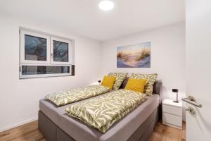 a bed with yellow pillows on it in a room at Relax Oase in Sasbachwalden