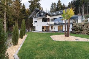 a white house with a palm tree in the yard at Relax Oase in Sasbachwalden