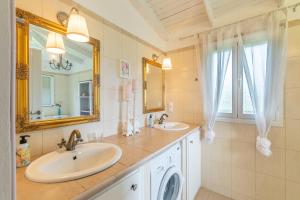 a bathroom with two sinks and a mirror at Blue apartment Corfu in Perivólion +15 photos