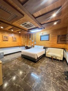 a bedroom with a bed and a couch and a table at Hola Hotel in Can Tho