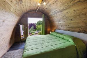 a bedroom with a green bed in a wooden wall at Cascina Manzo in Dogliani +125 photos