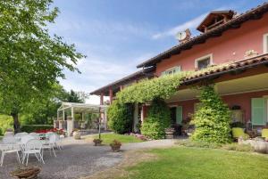 a house with a table and chairs in the yard at Cascina Manzo in Dogliani