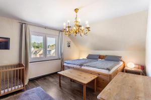 a bedroom with a bed and a table and a chandelier at Ferienwohnung Schlossbergblick in Arnsberg