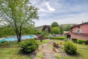 a garden with a swimming pool and a house at Cascina Manzo in Dogliani