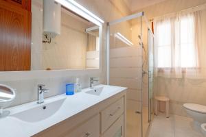 a bathroom with a sink and a toilet and a mirror at Villa Rosa in Cala Santanyi +26 photos