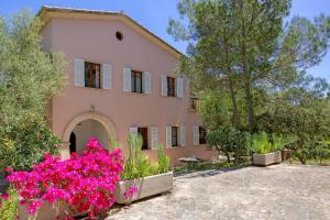 a house with pink flowers in front of it at Villa Rosa in Cala Santanyi