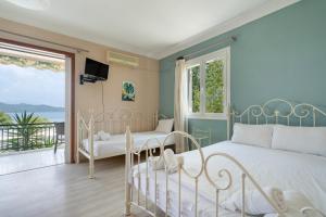 a bedroom with a white bed and a balcony at Giorgio studios-apartments 1 in Nikiana