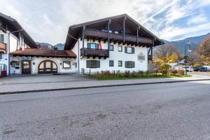 a white building with a brown roof on a street at Chalet Alpenherz in Inzell