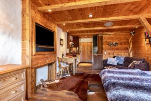 a living room with a couch and a tv in a cabin at Chalet Alpenherz in Inzell