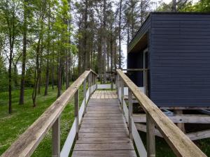 a wooden bridge leading to a cabin in the woods at La Cafoutche de Minus rénovée 2pers in Gommenecʼh +13 photos