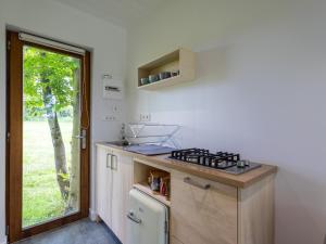 a small kitchen with a stove and a window at La Cafoutche de Minus rénovée 2pers in Gommenecʼh