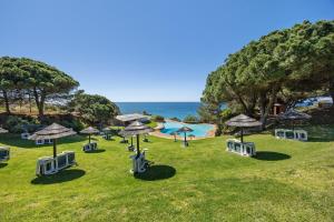 a resort with a pool and umbrellas and the ocean at V-Blue in Alvor