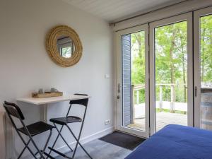 a bedroom with a bed and a desk and chairs at La Cafoutche de Minus rénovée 2pers in Gommenecʼh