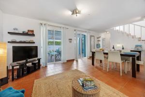 a living room with a television and a dining table at V-Blue in Alvor