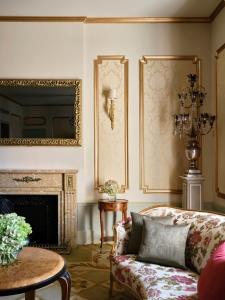 a living room with a couch and a fireplace at Hotel El Palace Barcelona in Barcelona