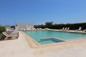 a large swimming pool with lounge chairs and a building at Bungalow Vittoria in Otranto