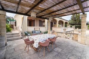 a patio with a table and chairs under a pergola at Villa Serra in Marina Serra