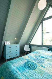 a attic bedroom with a bed and a window at Ferienhaus Waldperle in Ronshausen
