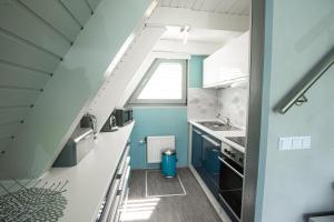 a kitchen with blue and white cabinets and a window at Ferienhaus Waldperle in Ronshausen