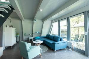 a living room with a blue couch and chairs at Ferienhaus Waldperle in Ronshausen