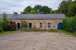 an old brick building with a blue door at Daol Grenn in Pluvigner