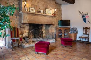 a living room with a fireplace with two chairs and a tv at Daol Grenn in Pluvigner