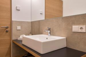 a bathroom with a white sink and a mirror at Ferienwohnungen Karin - Merlot in Termeno +19 photos