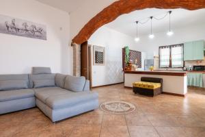 a living room with a couch and a kitchen at Villa Mavi in Quartucciu