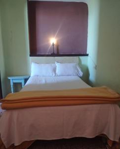 a bed in a room with a light above it at Beach House B2 in Kenitra +1 photo