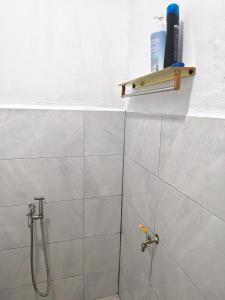 a bathroom with a shower with a shower head at Homestay Ayong in Parit Raja