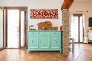 a blue cabinet in a living room with windows at Villa Mavi in Quartucciu