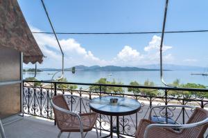 a balcony with a table and chairs and a view of the water at Giorgio studios-apartments 1 in Nikiana