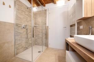a glass shower in a bathroom with a sink at Family House Il Butto in Erve +29 photos