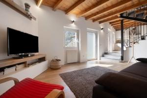 a living room with a flat screen tv on a wall at Family House Il Butto in Erve