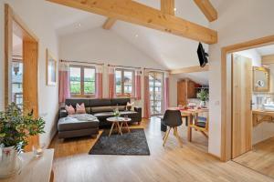 a living room with a couch and a table at Neubau - Ferienwohnung Waldblick in Höslwang