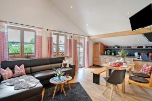 a living room with a couch and a table at Neubau - Ferienwohnung Waldblick in Höslwang