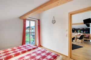 a bedroom with a bed and a large window at Neubau - Ferienwohnung Waldblick in Höslwang