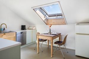 a kitchen with a table and chairs and a window at Urlaubsapartment Südsicht in Ihringen