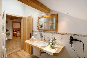 a bathroom with a sink and a mirror at Neubau - Ferienwohnung Waldblick in Höslwang +25 photos