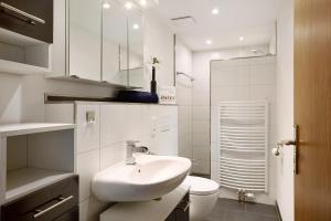 a white bathroom with a sink and a toilet at Ruhrtalblick in Bestwig +12 photos