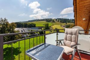 a patio with a table and a chair on a balcony at Haus Schönblick - "Fewo Sarina 2" in Willingen
