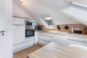 a white kitchen with white cabinets and a window at Haus Schönblick - "Fewo Sarina 2" in Willingen