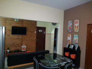 Una sala de estar con un sofá y un televisor en una pared. en Almancil Hostel, en Almancil