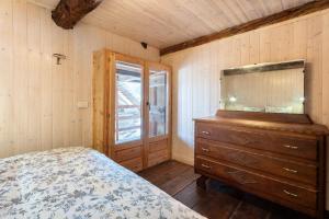 a bedroom with a bed and a dresser and a window at Chalet Tomidicarta in Trasquera